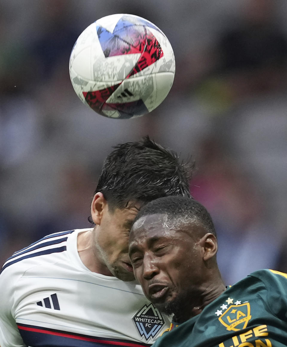 Los Angeles Galaxy's Kelvin Leerdam, right, and Vancouver Whitecaps' Brian White vie for the ball during the first half of an MLS soccer match Saturday, July 15, 2023, in Vancouver, British Columbia. (Darryl Dyck/The Canadian Press via AP)