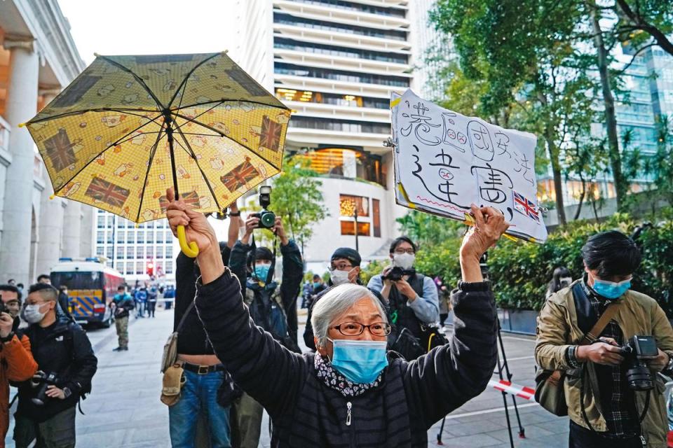 香港知名社運人士「王婆婆」曾聲援黎智英。圖為她高舉黃傘與自製的「港區國安法違憲」標語牌。（達志影像）