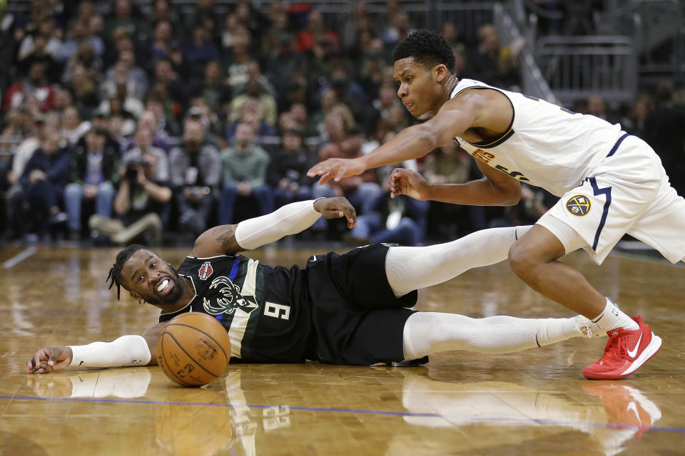 Milwaukee Bucks' Wesley Matthews (9) and Denver Nuggets' PJ Dozier dive for a loose ball during the first half of an NBA basketball game Friday, Jan. 31, 2020, in Milwaukee. (AP Photo/Aaron Gash)