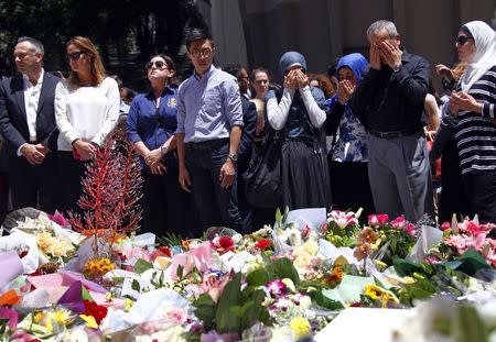 Members of the Australian Muslim community pray after placing floral tributes amongst thousands of others near the Lindt cafe, where hostages were held for over 16-hours, in central Sydney December 16, 2014. REUTERS/David Gray