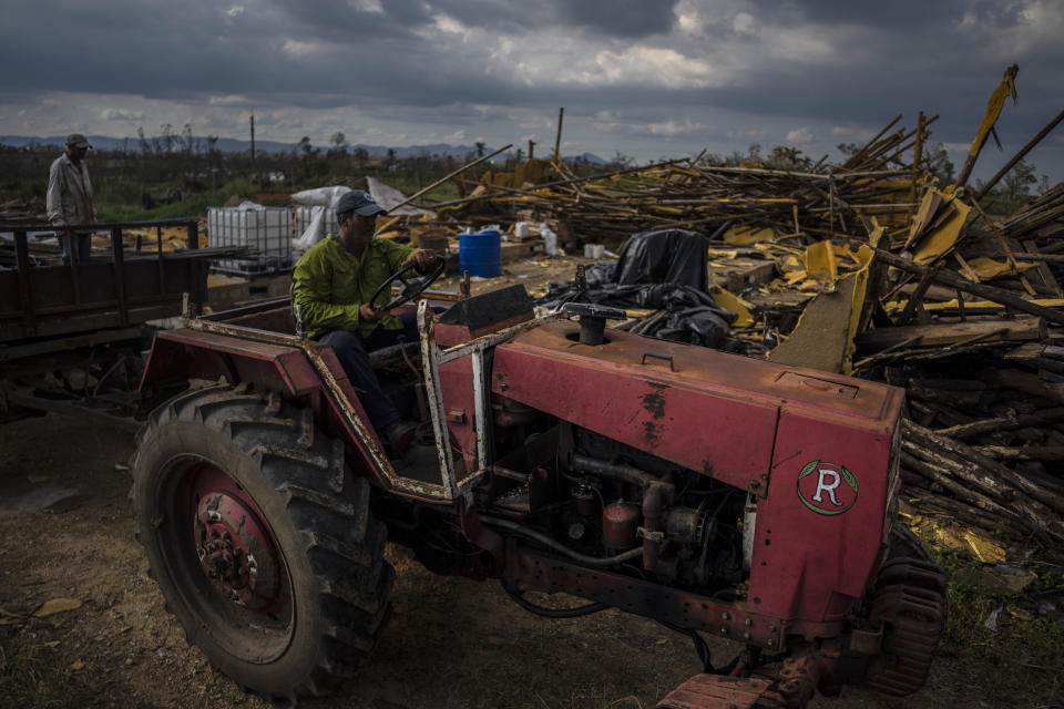 Tobacco farmer Hirochi Robaina drives his tractor past destroyed tobacco barns on his farm one week after Hurricane Ian in San Luis, in Pinar del Rio province, Cuba, Wednesday, Oct. 5, 2022 (AP Photo/Ramon Espinosa)