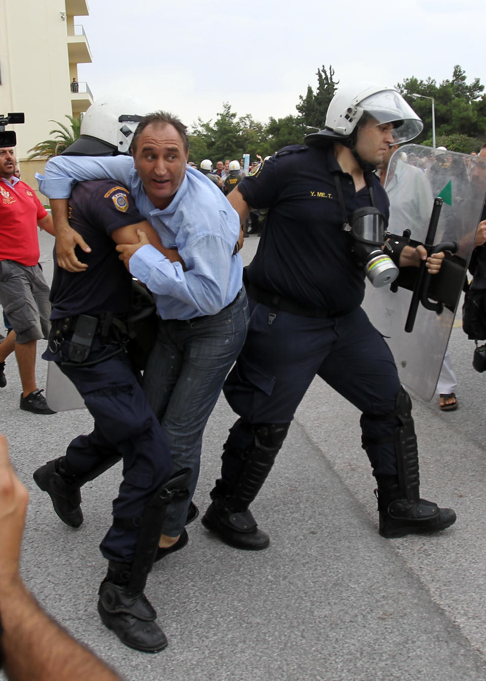 Riot police arrest a protester inside Greece's Defense Ministry in Athens, Thursday, Oct. 4, 2012. Police clashed with scores of protesting shipyard workers after they forced their way into the grounds of Greece's Defense Ministry. The workers say they have not been paid in months. (AP Photo/Thanassis Stavrakis)