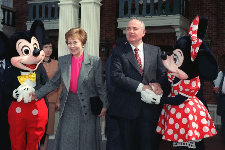 El expresidente soviético Mijail Gorbachov y su esposa Raisa se dan la mano con Mickey y Minnie Mouse en la entrada de Tokyo Disneyland, el 12 de abril de 1992