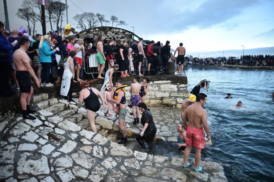 carnlough, northern ireland january 01 a large crowd of spectators watch swimmers as they take part in the annual new years day swim at carnlough harbour on january 1, 2018 in carnlough, northern ireland photo by charles mcquillangetty images