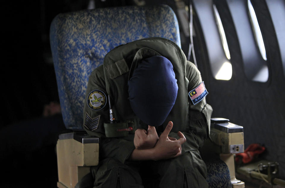 A crew member of a Royal Malaysian Air Force CN-235 aircraft rests after long hours working in a search and rescue operation for the missing Malaysia Airlines plane over the Straits of Malacca, Thursday, March 13, 2014. Planes sent Thursday to check the spot where Chinese satellite images showed possible debris from the missing Malaysian jetliner found nothing, Malaysia's civil aviation chief said, deflating the latest lead in the six-day hunt. The hunt for the missing Malaysia Airlines flight 370 has been punctuated by false leads since it disappeared with 239 people aboard about an hour after leaving Kuala Lumpur for Beijing early Saturday. (AP Photo/Lai Seng Sin)