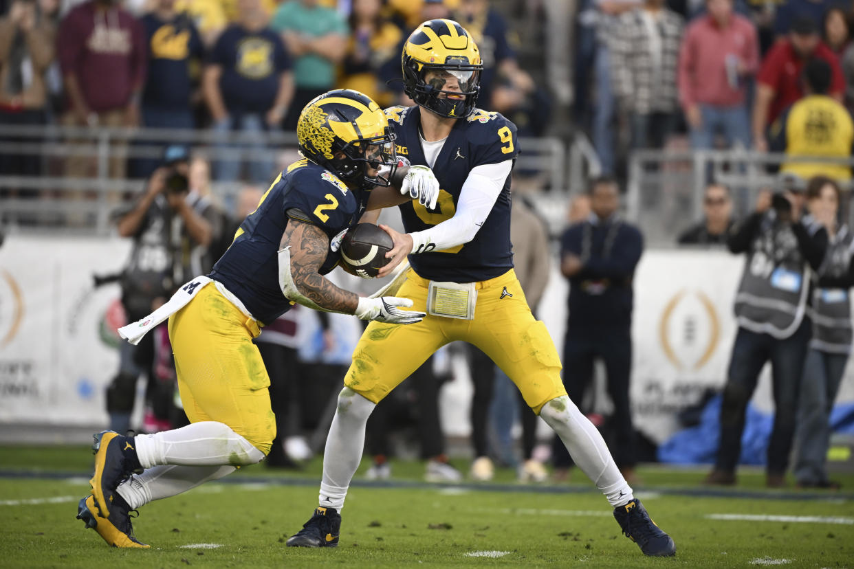 Michigan quarterback J.J. McCarthy (9) hands off to Michigan running back Blake Corum (2) during the second half of the Rose Bowl CFP NCAA semifinal college football game against Alabama Monday, Jan. 1, 2024, in Pasadena, Calif. (AP Photo/Kyusung Gong)