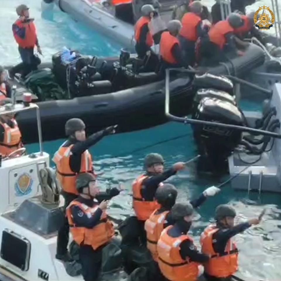 Chinese Coast Guard holding knives and machetes as they approach Philippine troops in the Second Thomas Shoal at the disputed South China Sea