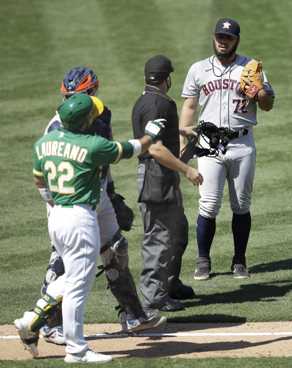 Oakland Athletics' Ramon Laureano (22) gestures to Houston Astros pitcher Humberto Castellanos, right, after being hit by a pitch thrown by Castellanos in the seventh inning of a baseball game Sunday, Aug. 9, 2020, in Oakland, Calif. (AP Photo/Ben Margot)