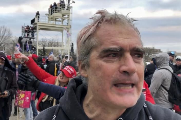 This image from video recorded Jan. 6, 2021, captures Vincent Gillespie on the grounds of the U.S. Capitol in Washington where prosecutors say he was among a rioting mob trying to gain control of the building from the federal government. (AP Photo/Ben Fox)
