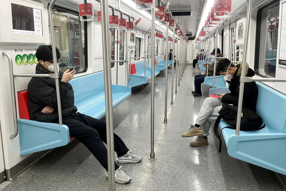 Commuters wear protective masks while they ride a subway train as coronavirus disease (COVID-19) outbreaks continue in Shanghai, China, December 20, 2022. REUTERS/Casey Hall