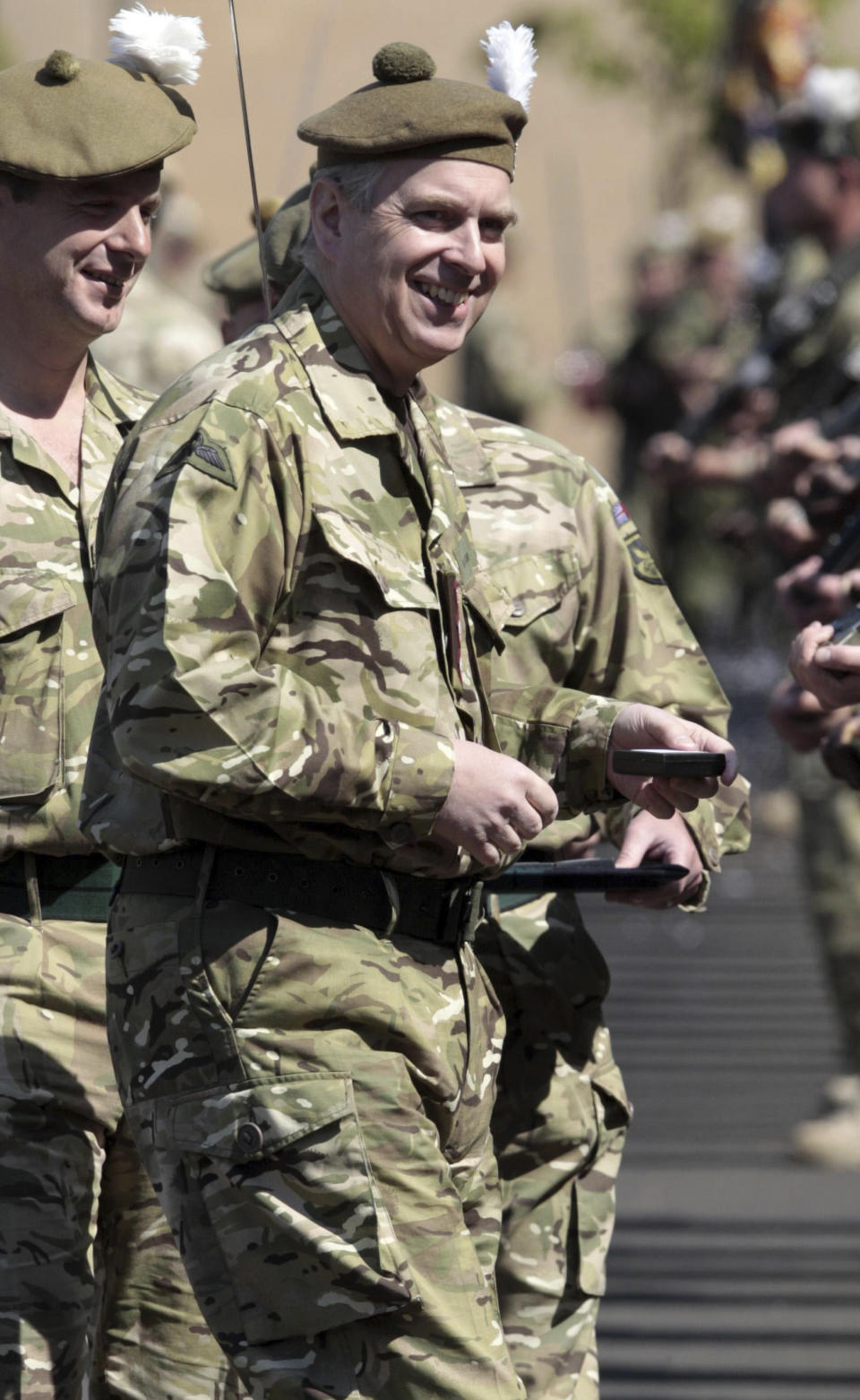 FILE Britain's Prince Andrew watches as soldiers from Royal Highland Fusiliers 2nd Battalion, the Royal Regiment of Scotland (2 SCOTS), take part in a homecoming Parade in Penicuik, Scotland, May 4, 2011. Buckingham Palace says that Prince Andrew’s military affiliations and royal patronages have been returned to Queen Elizabeth II with her “approval and agreement.” The palace statement issued on Thursday, Jan. 13, 2022 came after more than 150 navy and army veterans wrote to the queen asking her to strip Andrew of all his military ranks and titles amid continued legal trouble for the prince, who is embroiled in a sex assault lawsuit in the U.S. (David Cheskin/PA via AP, File)