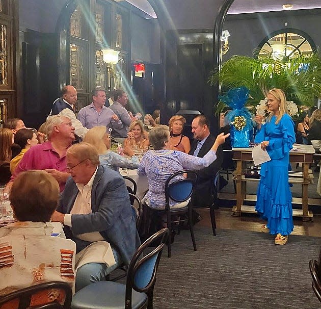 Cafe L'Europe co-owner Emanuela Marcello emcees a trivia quiz at a wine dinner.