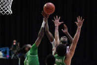 Western Kentucky guard Josh Anderson shoots over North Texas guard James Reese, left, and forward Zachary Simmons (24) during the second half of the championship game in the NCAA Conference USA men's basketball tournament Saturday, March 13, 2021, in Frisco, Texas. (AP Photo/Tony Gutierrez)