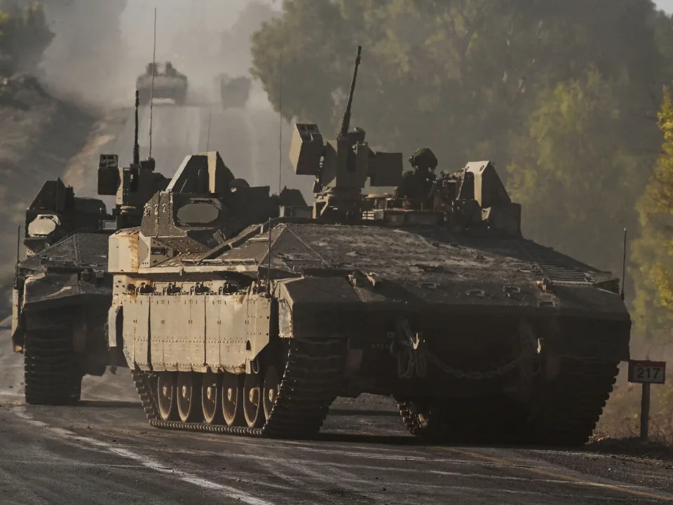 Israeli army armoured vehicles roll towards the border with the Gaza Strip at an undisclosed location in southern Israel on October 15, 2023.