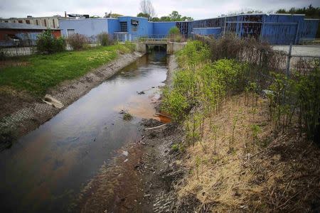 Beaver Brook, a source of large flooding, flows under the unoccupied and defunct Kingsbury manufacturing plant in Keene, New Hampshire May 16, 2014. REUTERS/Brian Snyder