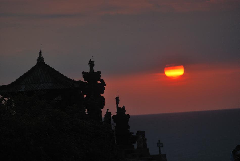 <b>Sunset at Tanah Lot temple in Bali, Indonesia</b><br><br>No trip is complete without a glimpse of the spectacular sunset in Tanah Lot temple, a tourist magnet located on a rocky oceanic island. The 15th century shrine, dedicated to the sea spirits, was built under the direction of a priest and is believed to be guarded by snakes.