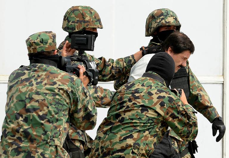 Mexican drug trafficker Joaquin Guzman Loera aka "el Chapo Guzman", is escorted by marines as he is presented to the press on February 22, 2014 in Mexico City