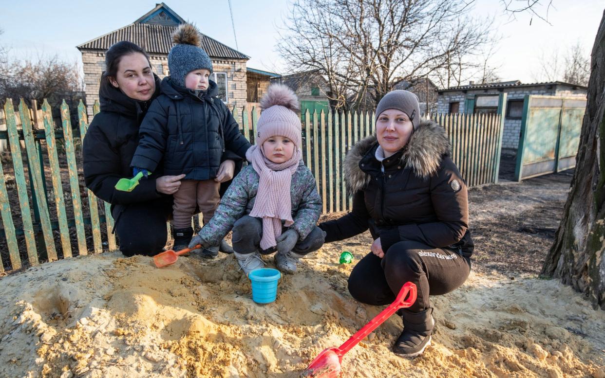 Two mothers and their children play in the village of Halytsynivka, near Avdiivka