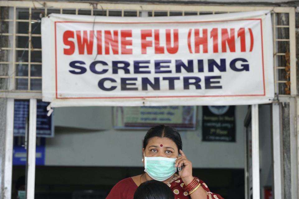 <span class="caption">A woman wearing a mask talks on her mobile phone outside the H1N1 swine flu screening centre at the Government Gandhi Hospital in Hyderabad on Aug. 7, 2010.</span> <span class="attribution"><a class="link " href="https://www.gettyimages.com/detail/news-photo/an-indian-woman-wearing-a-mask-talks-on-her-mobile-phone-news-photo/103277741?adppopup=true" rel="nofollow noopener" target="_blank" data-ylk="slk:Noah Seelam/AFP via Getty Images;elm:context_link;itc:0;sec:content-canvas">Noah Seelam/AFP via Getty Images</a></span>