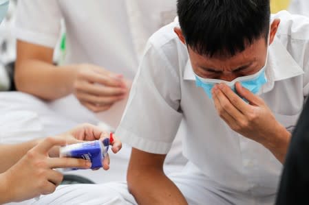 A schoolmate of a student protester who was shot by a policeman on Tuesday cries while participating in a student gathering at Tsuen Wan Public Ho Chuen Yiu Memorial College in solidarity with the student in Tsuen Wan