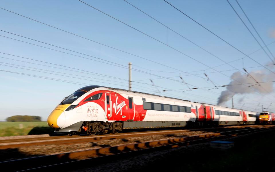 Virgin Trains' new Azuma travels in the same direction alongside the The Flying Scotsman and two of the rail operator's revitalised present day fleet - to depict the past, present and future of UK rail travel, in a world first event, in the North Yorkshire countryside - Credit: PA