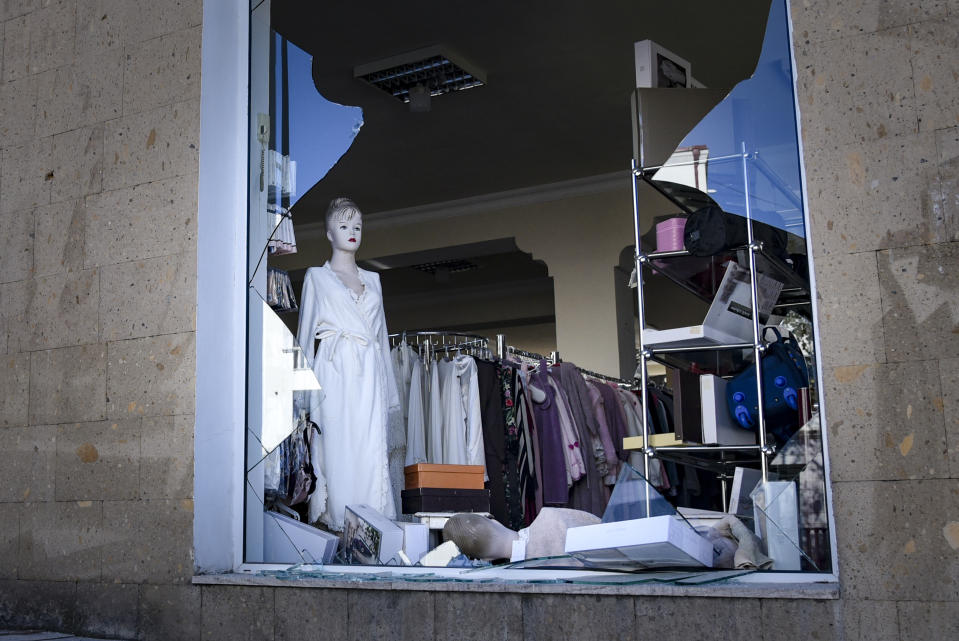 A view of a window of a clothing store, hit by shelling, during a military conflict in Stepanakert in the separatist region of Nagorno-Karabakh, Saturday, Oct. 17, 2020. Stepanakert, the regional capital of Nagorno-Karabakh, came under intense shelling overnight, leaving three civilians wounded, according to separatist authorities. (David Ghahramanyan, NKR InfoCenter/PAN Photo via AP)