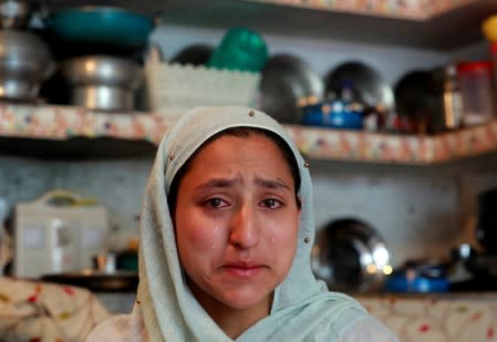 Woman weeps inside her house after her household goods were allegedly damaged by Indian security forces following clashes between protesters and the security forces on Friday evening, in Srinagar