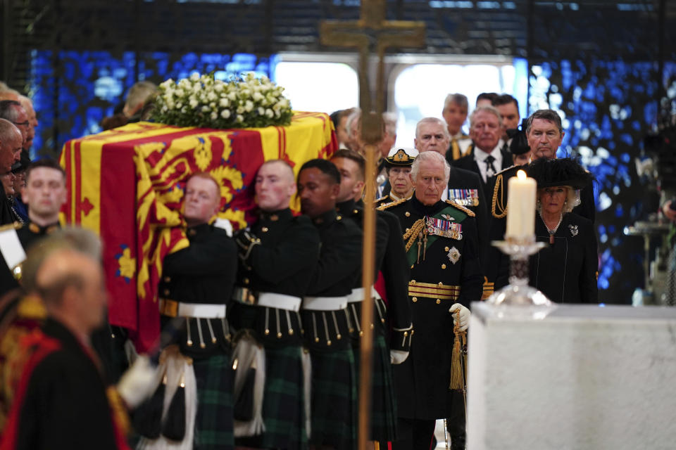 El rey Carlos III, centro al frente, la reina consorte Camila, la princesa Ana,Tim Laurence, y el príncipe Andrés siguen el ataúd de la reina Isabel II al entrar a la Catedral de San Giles para una misa conmemorativa para la reina el lunes 12 de septiembre de 2022. (Jane Barlow/PA via AP)