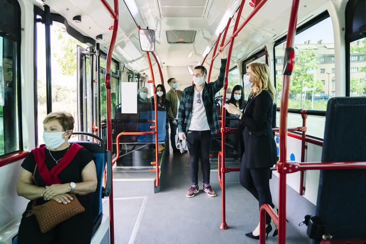 masked people riding the bus