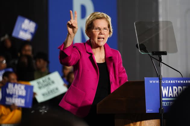 Sen. Elizabeth Warren (D-Mass.), holds up two fingers to represent her two-cent wealth tax while speaking at a campaign event during her presidential campaign in 2019.