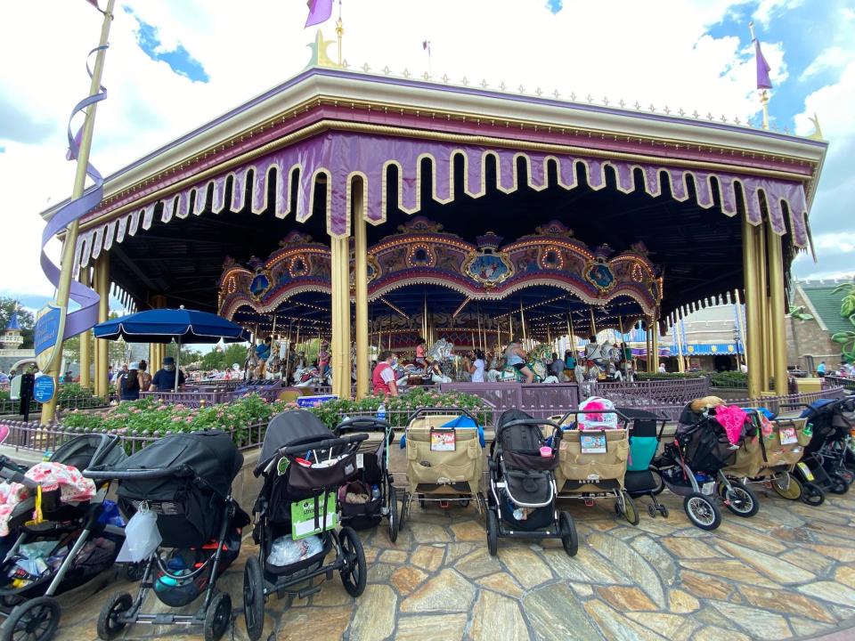Strollers in front of Prince Charming Regal Carrousel at Disney World in August 2021.