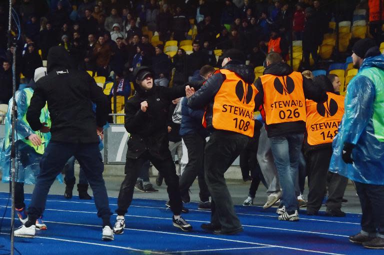 Dynamo Kiev's supporters fight with security guards during the UEFA Europa League match against Guingamp in Kiev on February 26, 2015