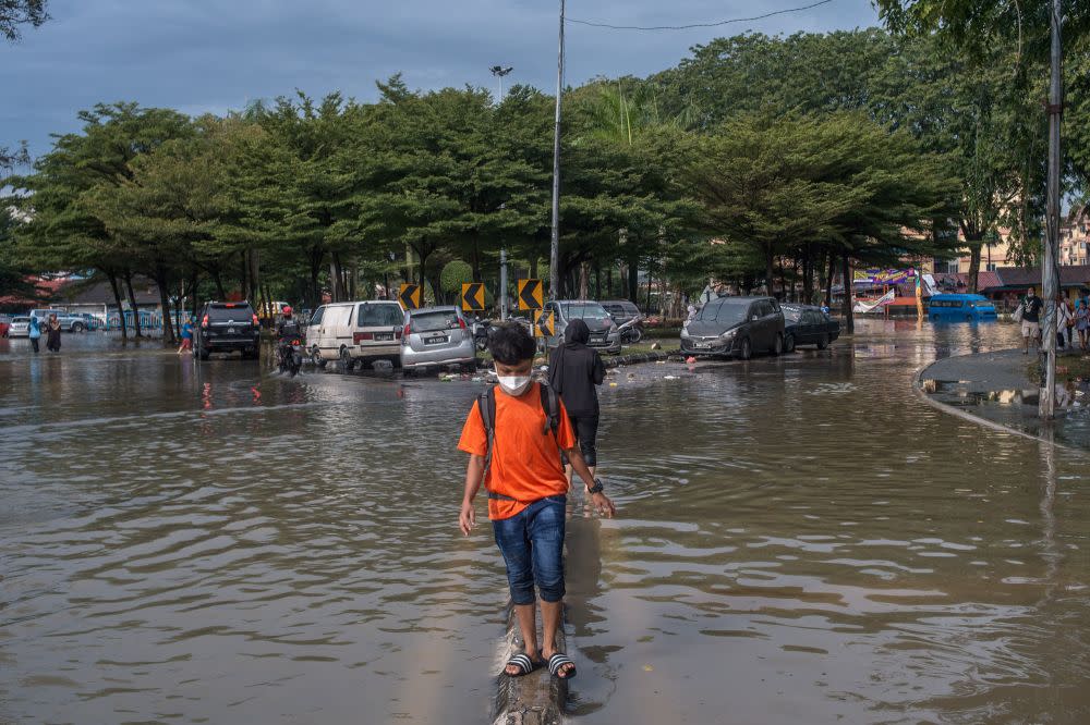 A boy wades through floodwaters in Taman Sri Muda, Shah Alam December 22, 2021. ― Picture by Shafwan Zaidon