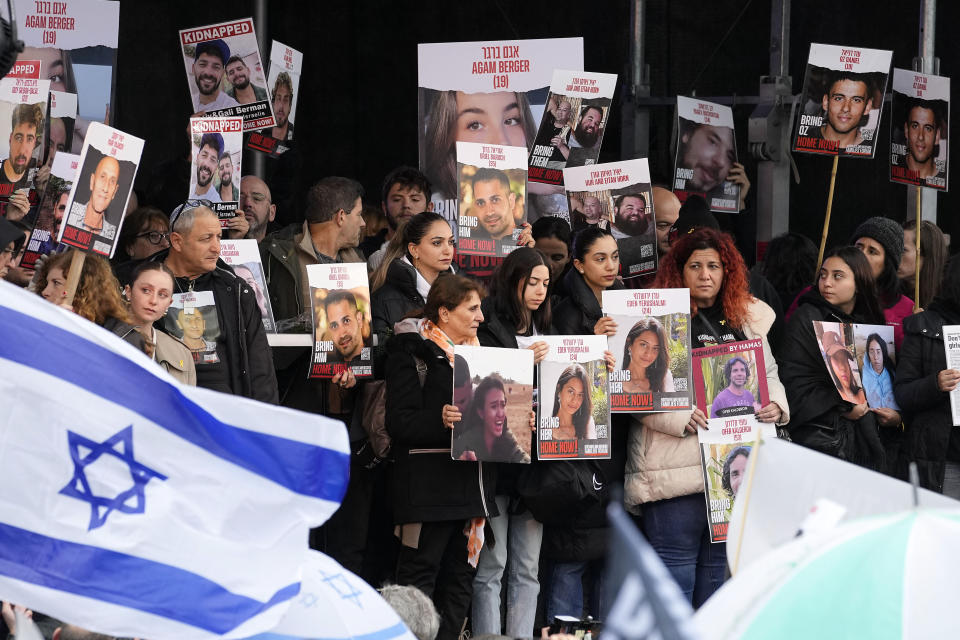 Families of hostages and former hostages hold images on a podium at a protest near the International Crime Court at The Hague during a protest of representatives of families of hostages from the Oct. 7 cross-border attack by Hamas on Israel, in The Hague, Netherlands, Wednesday, Feb. 14, 2024. The Hostages Families Forum together with the Raoul Wallenberg Center for Human Rights is submitting a comprehensive complaint to the International Criminal Court on behalf of released hostages and families of hostages, including the issuance of arrest warrants for Hamas leaders on war crimes allegations including taking hostages, enforced disappearances, sexual violence and torture. (AP Photo/Martin Meissner)