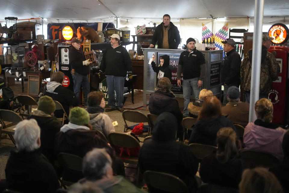 An auctioneer takes bids for antiques during the 56th annual mud sale to benefit the local fire department in Gordonville, Pa., Saturday, March 9, 2024. Mud sales are a relatively new tradition in the heart of Pennsylvania's Amish country, going back about 60 years and held in early spring as the ground begins to thaw but it's too early for much farm work. (AP Photo/Matt Rourke)