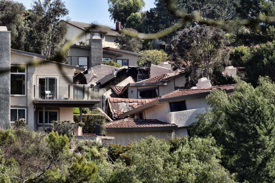 Homes in Southern California's Palos Verdes Peninsula are seen torn apart by earth movement in Rolling Hills Estates, Calif. on Monday, July 10, 2023. A dozen homes torn apart by earth movement during the weekend are likely to fall into an adjacent canyon. The homes in the Los Angeles County city of Rolling Hills Estates were hastily evacuated by firefighters Saturday when cracks began appearing in structures and the ground. (AP Photo/Richard Vogel)