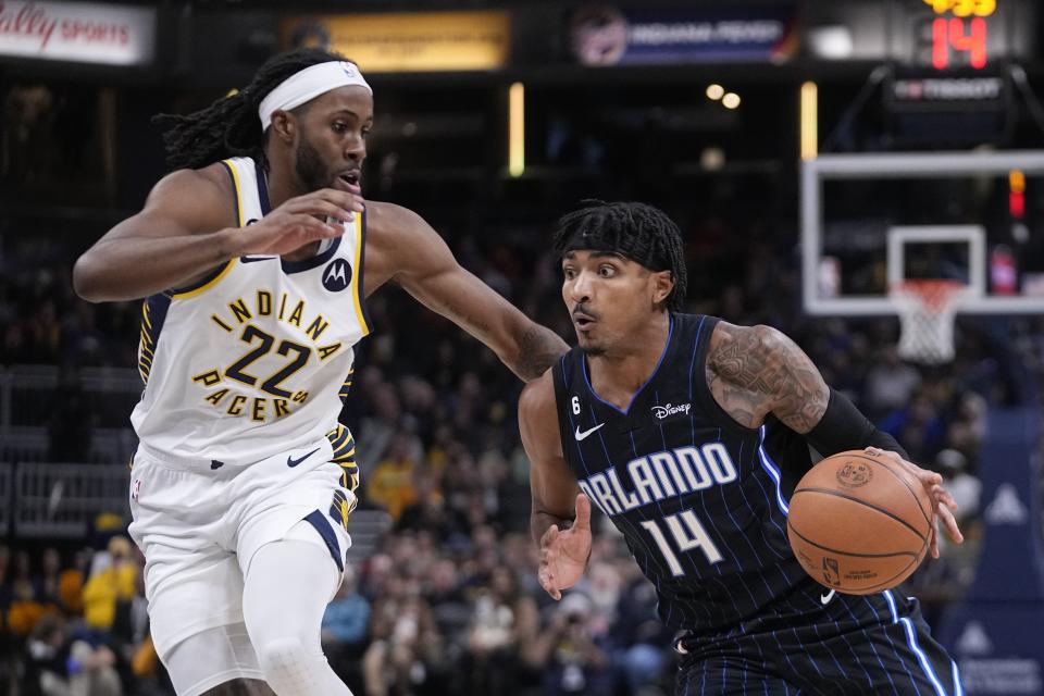 Orlando Magic's Gary Harris (14) is defended by Indiana Pacers' Isaiah Jackson (22) during the first half of an NBA basketball game, Monday, Nov. 21, 2022, in Indianapolis. AP Photo/Darron Cummings)