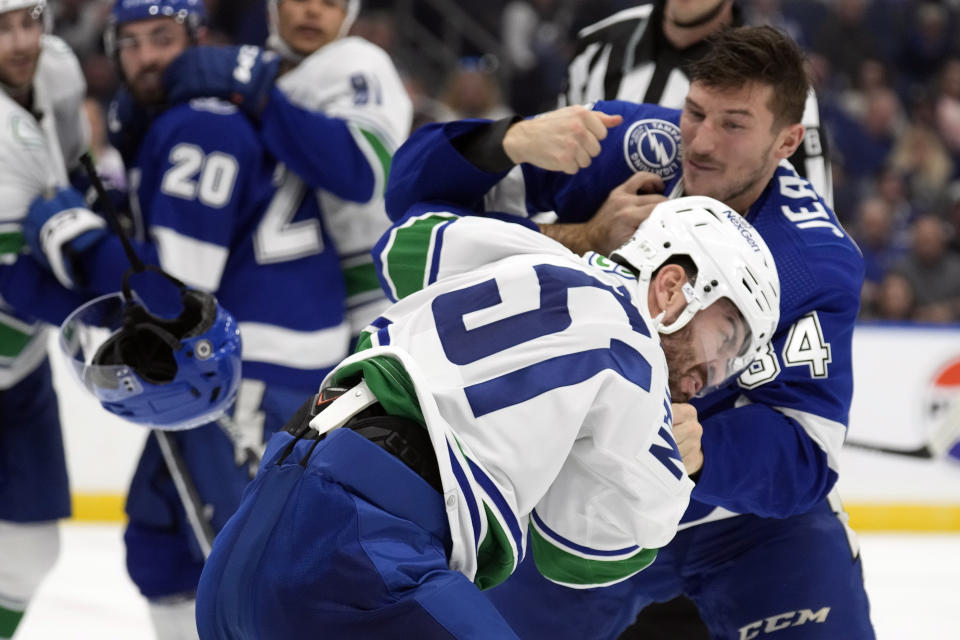 Vancouver Canucks Mark Friedman and Tampa Bay Lightning left wing Tanner Jeannot (84) fight during the second period of an NHL hockey game Thursday, Oct. 19, 2023, in Tampa, Fla. (AP Photo/Chris O'Meara)