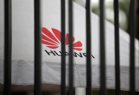 A Huawei logo is seen outside the fence at its headquarters in Shenzhen