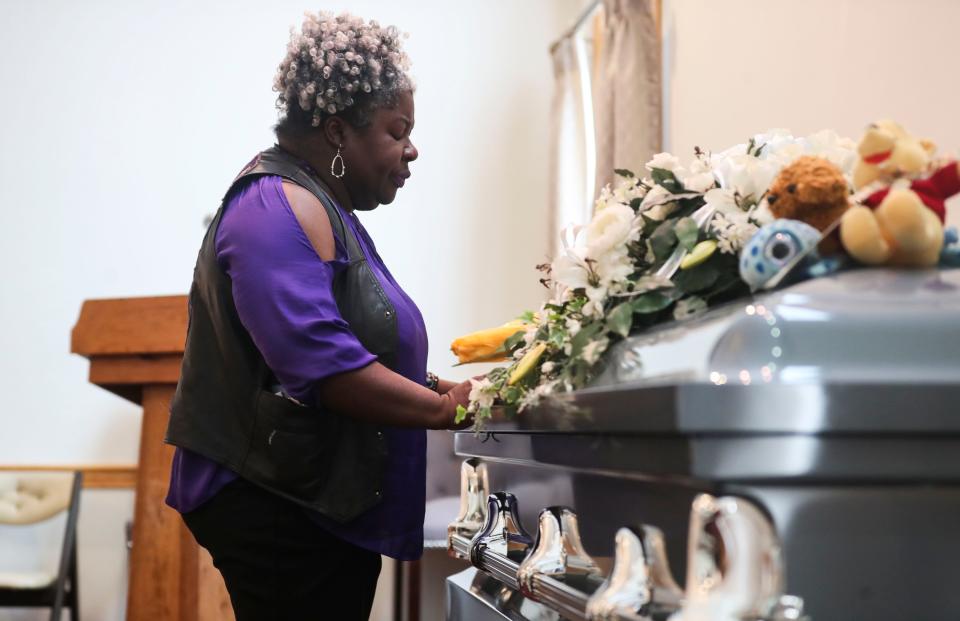 u0022I'm so sorry,u0022 whispers Katrina Bailey of New Albany, Indiana, to the casket for an unidentified boy after a memorial service for him Wednesday in Salem.