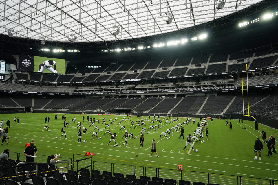 CORRECTS TO $2 BILLION, NOT 1.9 BILLION AS ORIGINALLY SENT - FILE - In this Aug. 21, 2020, file photo, Las Vegas Raiders players stretch during an NFL football training camp practice at Allegiant Stadium in Las Vegas. The NFL is opening in Sin City, something even the bookies in this gambling city would never have bet on happening. But on Monday night, Sept. 21, the gamble pays off when the Raiders meet the New Orleans Saints in the opening game of the glittering $2 billion stadium that Raiders owner Mark Davis dubbed the Death Star.(AP Photo/John Locher, File)