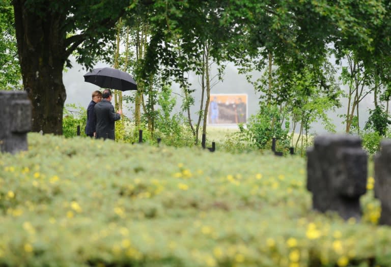 French President Francois Hollande and German Chancellor Angela Merkel walk through a German cemetery in Consenvoye, northeastern France on May 29, 2016 as part of a rememberance ceremony marking the Battle of Verdun in 1916