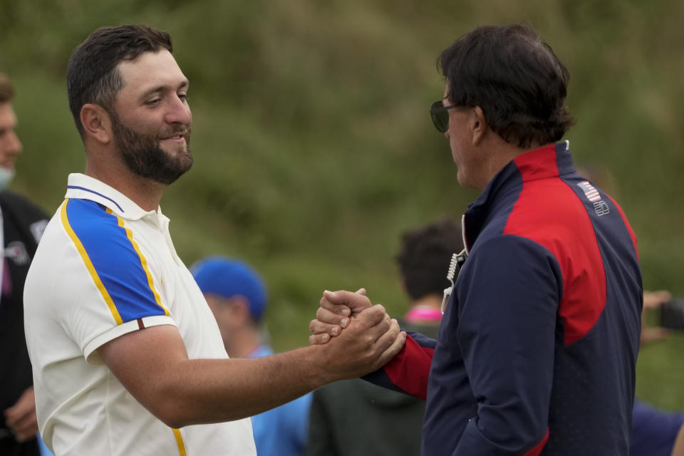 Team Europe's Jon Rahm shakes hands with Team USA assistant captain Phil Mickelson after the Ryder Cup matches at the Whistling Straits Golf Course Sunday, Sept. 26, 2021, in Sheboygan, Wis. (AP Photo/Charlie Neibergall)