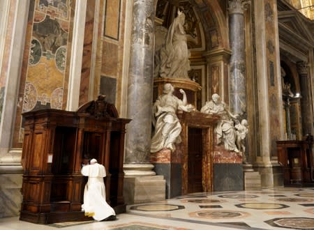 Pope Francis kneels before a priest to confess, during a penitential liturgy in St. Peter's Basilica at the Vatican