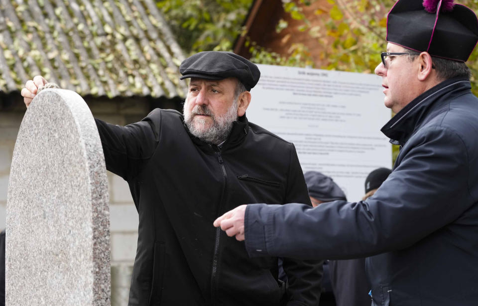 Poland's chief rabbi Michael Schudrich, left, and priest Zbigniew Kasprzyk stand together for prayers for the souls of some 60 Jews murdered by the occupying Nazi German forces during a ceremony marking a memorial to the victims in Wojslawice, Poland, Thursday Oct. 14, 2021. The grave is among many Holocaust graves that still exist across Poland today. In recent years they are being discovered, secured and marked. (AP Photo/Czarek Sokolowski)