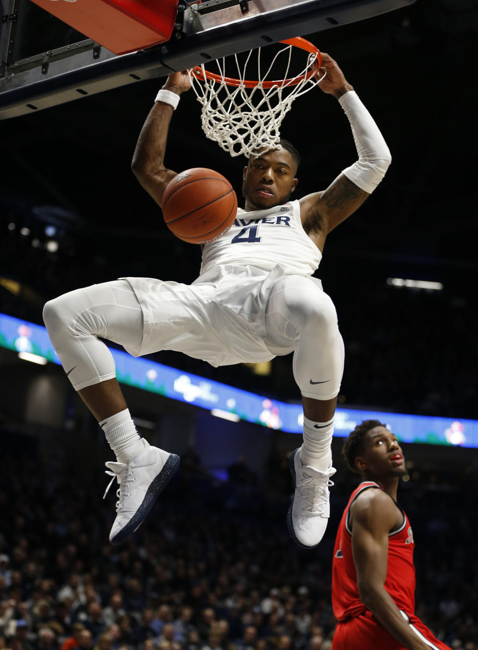 Xavier forward Tyrique Jones (4) dunks in front of St. John's forward Josh Roberts, right, during the first half of an NCAA college basketball game, Sunday, Jan. 5, 2020, in Cincinnati. (AP Photo/Gary Landers)