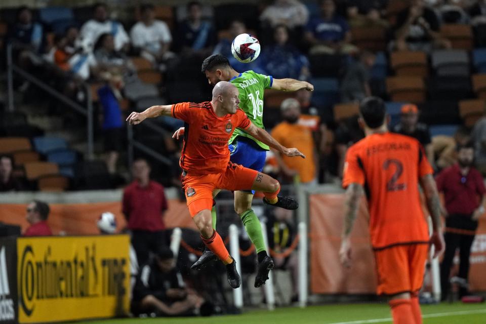 Seattle Sounders' Alex Roldan (16) and Houston Dynamo's Brad Smith g up for a header during the second half of an MLS soccer match Saturday, May 13, 2023, in Houston. (AP Photo/David J. Phillip)