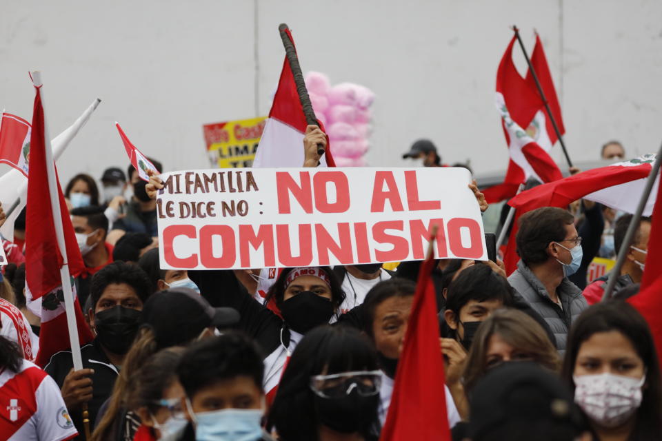 A supporter of presidential candidate Keiko Fujimori holds up a sign with a message that reads in Spanish: "My family says, No to Communism" during a protest against alleged election fraud, in Lima, Peru, Saturday, June 12, 2021. Supporters are hoping to reverse the results of the June 6th presidential runoff election that seem to have given the win to opponent Pedro Castillo amid unproven claims of possible vote tampering. (AP Photo/Guadalupe Pardo)