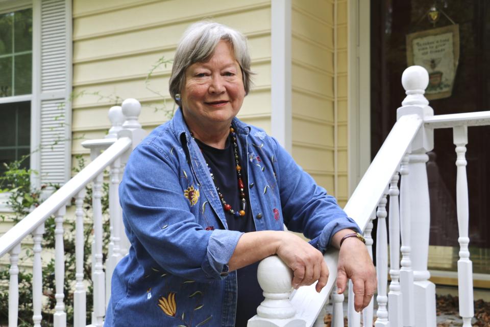 Margaret Toman, 78, stands on the steps of her home in Garner, North Carolina, on Wednesday, Oct. 12, 2022. She purchased the house to take care of her mother, who recently died of Alzheimer's disease, and is now struggling to pay the bills. (AP Photo/Hannah Schoenbaum)