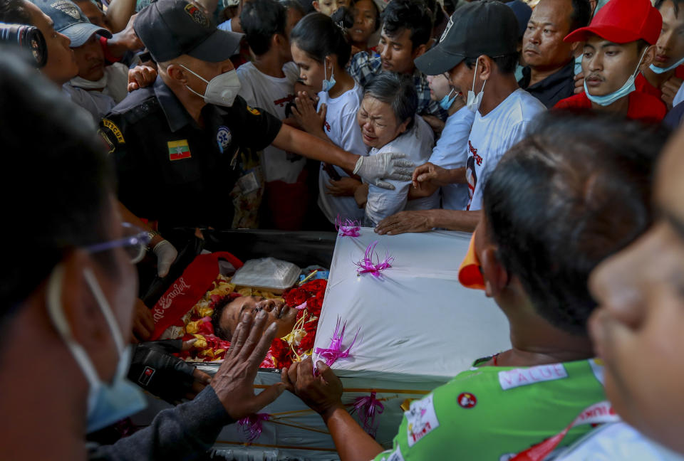 Tin Tin Win, center, weeps over the body of her son, Tin Htut Hein, at his funeral in Yangon, Myanmar, Wednesday, Feb. 24, 2021. Tin Htut Hein was shot on Saturday, Feb. 20, while acting as a volunteer guard for a neighborhood watch group that was set up over fears that authorities were using criminals released from prison to spread fear and commit violence. (AP Photo)